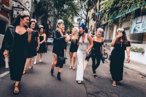 Urban wedding party walking along city street in casual celebratory mood.