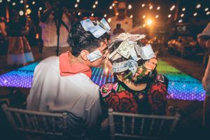 Wedding party dancing and celebrating on a colorful illuminated dance floor at night.