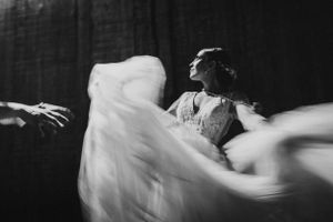 Dramatic black and white photo of dancing with flowing fabric motion blur.