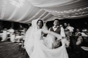 Multiple dance sequences at a wedding celebration shown in blurred motion on a dark background.