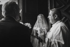 Black and white photo of reception guests mingling and celebrating at an indoor venue.