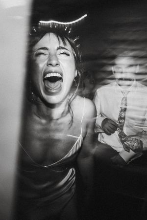 A candid black and white photo capturing pure joy and laughter at a celebratory event.