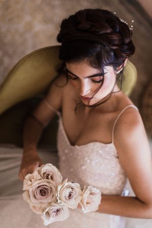 Elegant bride with roses in soft, romantic lighting.