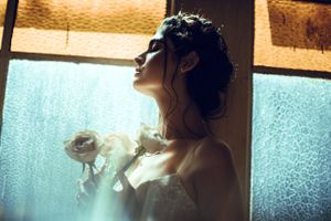 A dreamy backlit portrait with soft lighting through textured glass.
