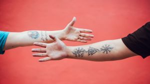 Sequential shots of hands with tattoos reaching out against a coral red background.