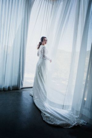 Ethereal sequence of a flowing white dress moving against sheer curtains in soft light.