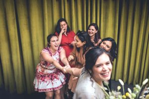 A candid group photo showing joyful laughter and celebration against a yellow curtain backdrop.