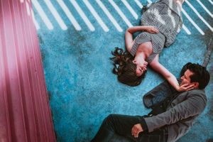 Series of artistic poses on a blue textured floor with diagonal striped lighting.