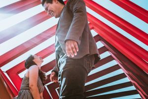Low angle view of people under red and white striped fabric creating geometric patterns.