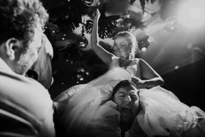 Black and white photo of celebratory moment with floating bubbles at wedding reception.
