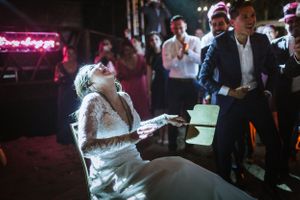 A reception party scene bathed in pink neon lighting as guests celebrate on the dance floor.