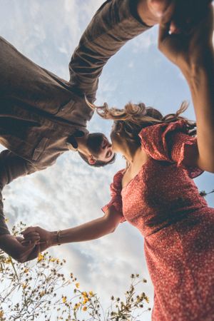 Dynamic low angle shot of two figures in motion against cloudy sky.