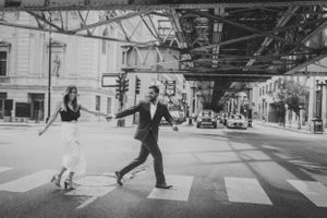 Person leaping across crosswalk in urban black and white street scene.