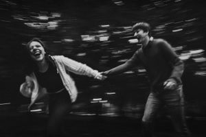 Black and white motion blur photo of two people running in dynamic composition.