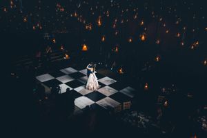 A romantic evening scene with floating lanterns illuminating a checkered dance floor.