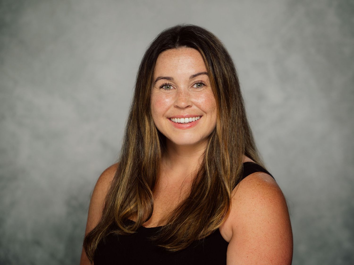 A series of professional portrait photos showing someone in a black top against a gray studio backdrop.