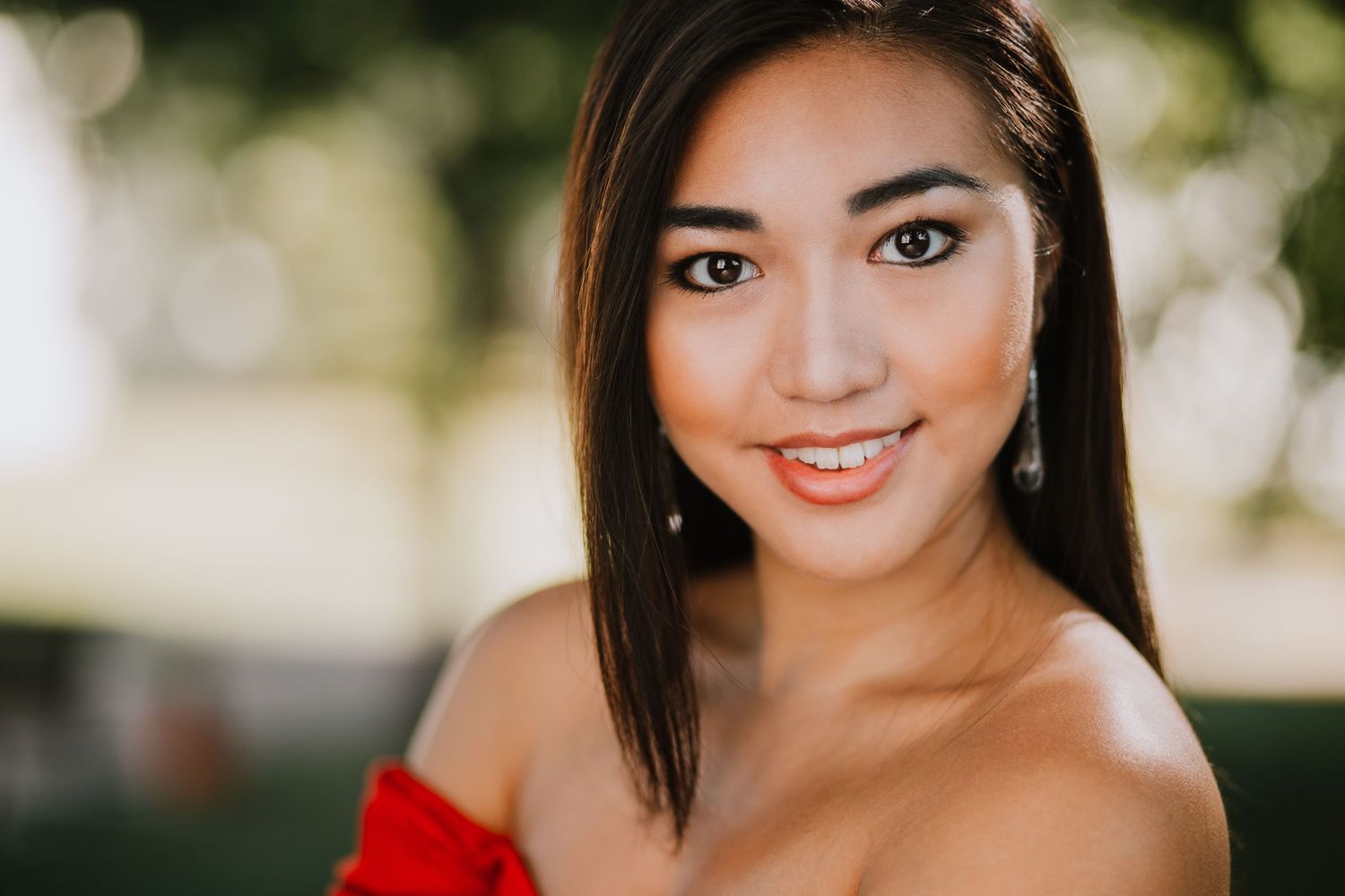 A woman in a red dress poses outdoors in a series of elegant portrait photographs.