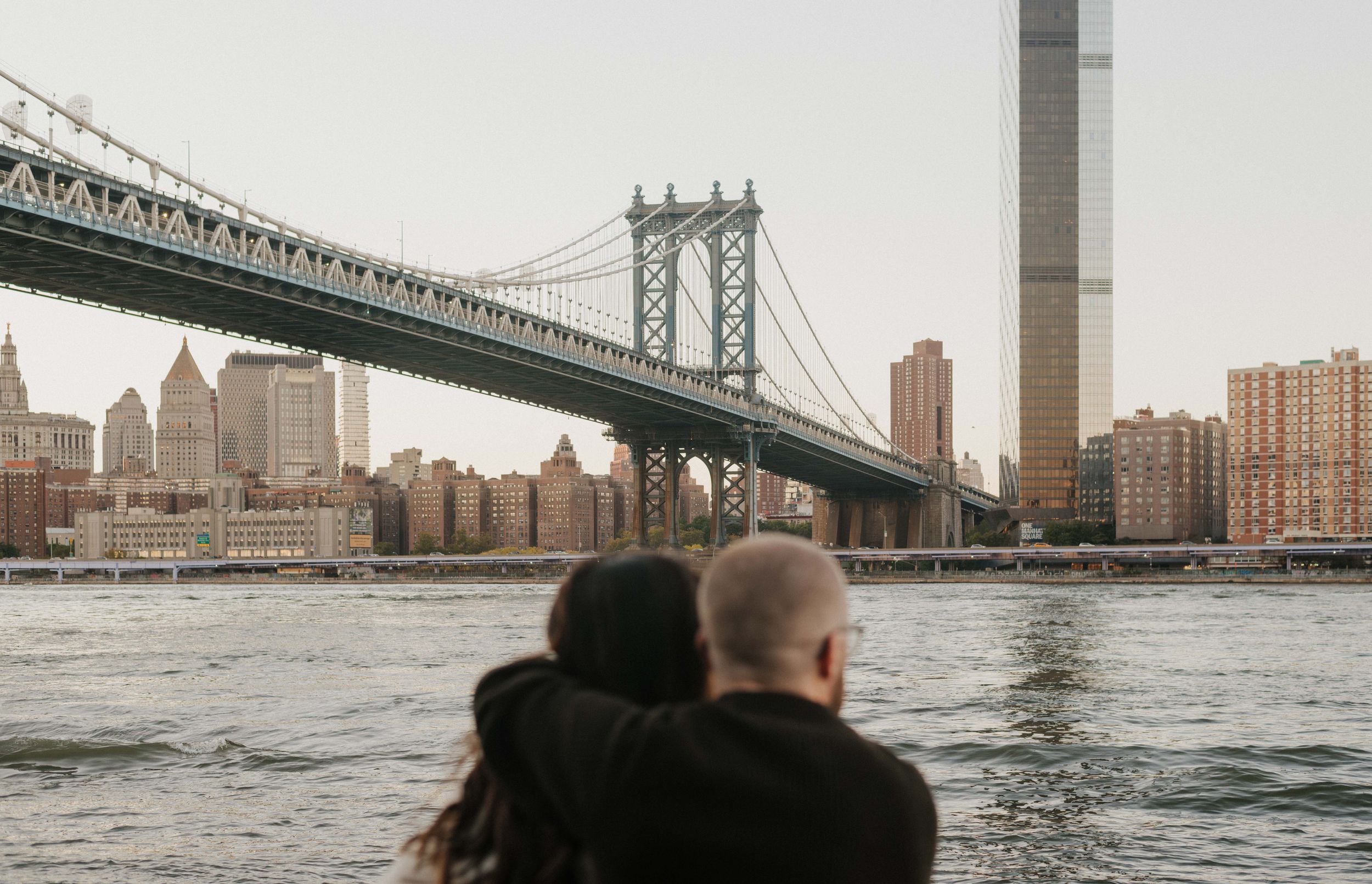Panoramic view of Manhattan Bridge and city skyline over East River in New York City.