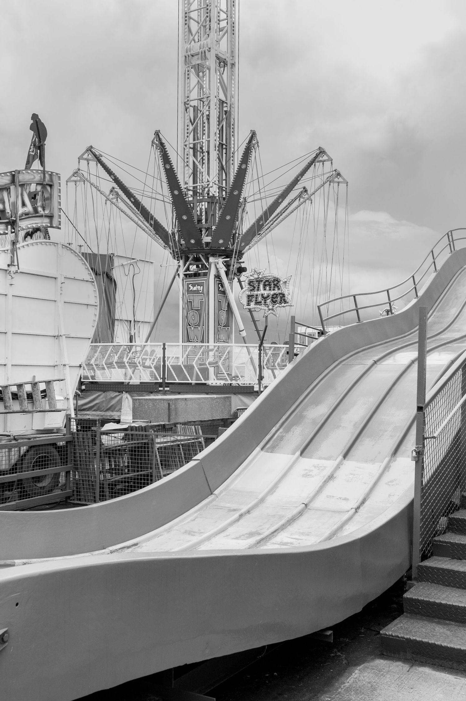 Sequence of black and white photos showing a large curved carnival ride ramp structure from different angles.