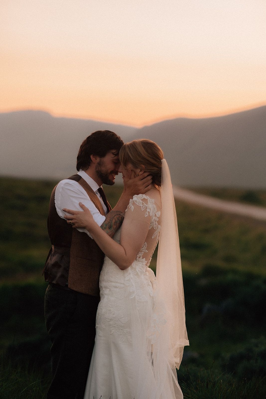 A romantic scene on a cobblestone street with blooming roses and historic church tower.