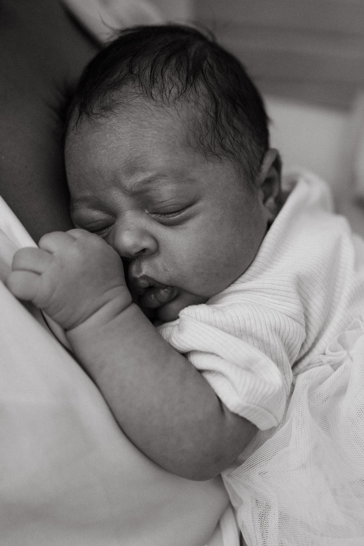 Sequential black and white photos capturing different angles of a peaceful sleeping newborn.