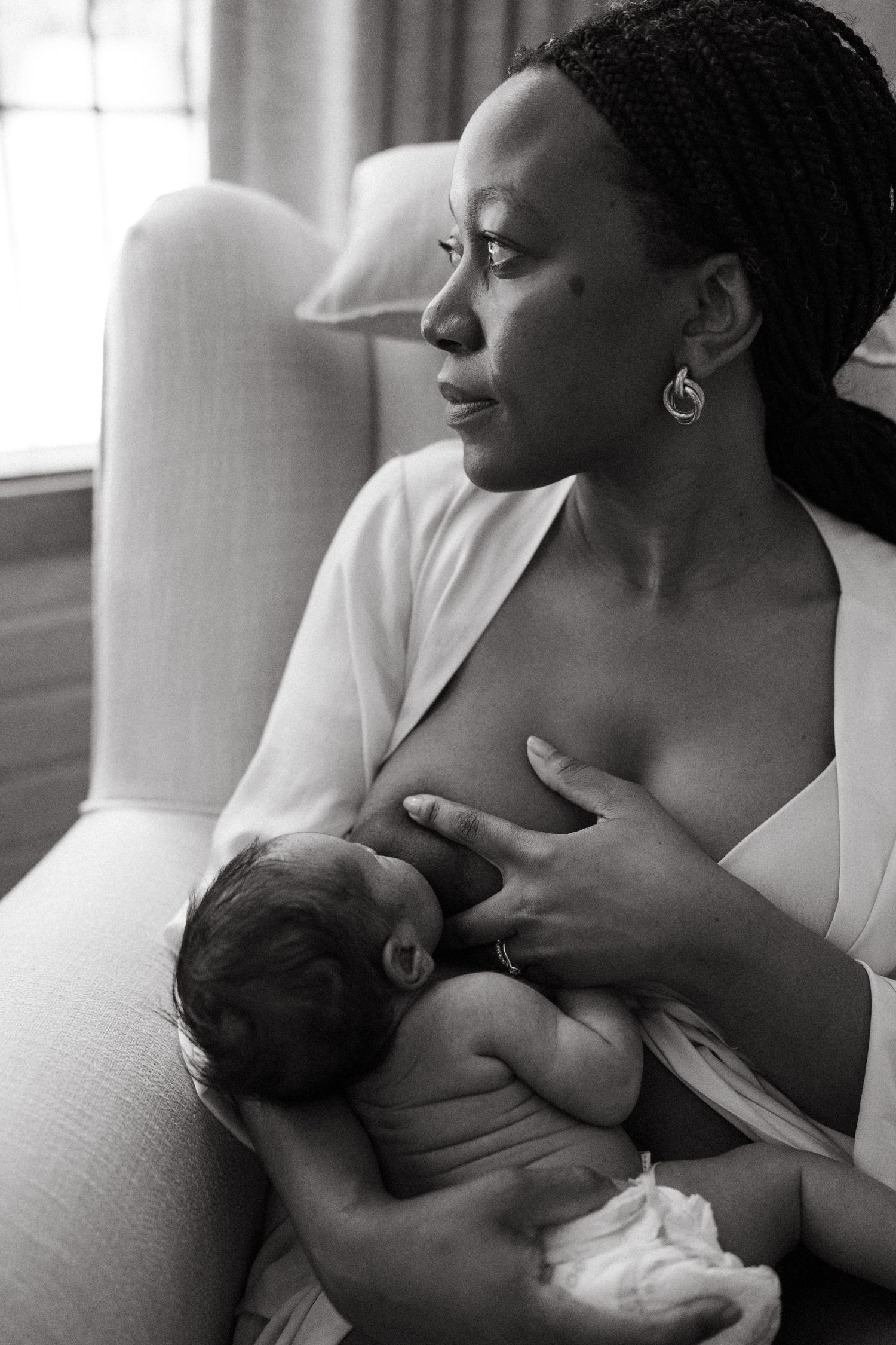 Intimate black and white photography series showing breastfeeding moments in a comfortable setting.