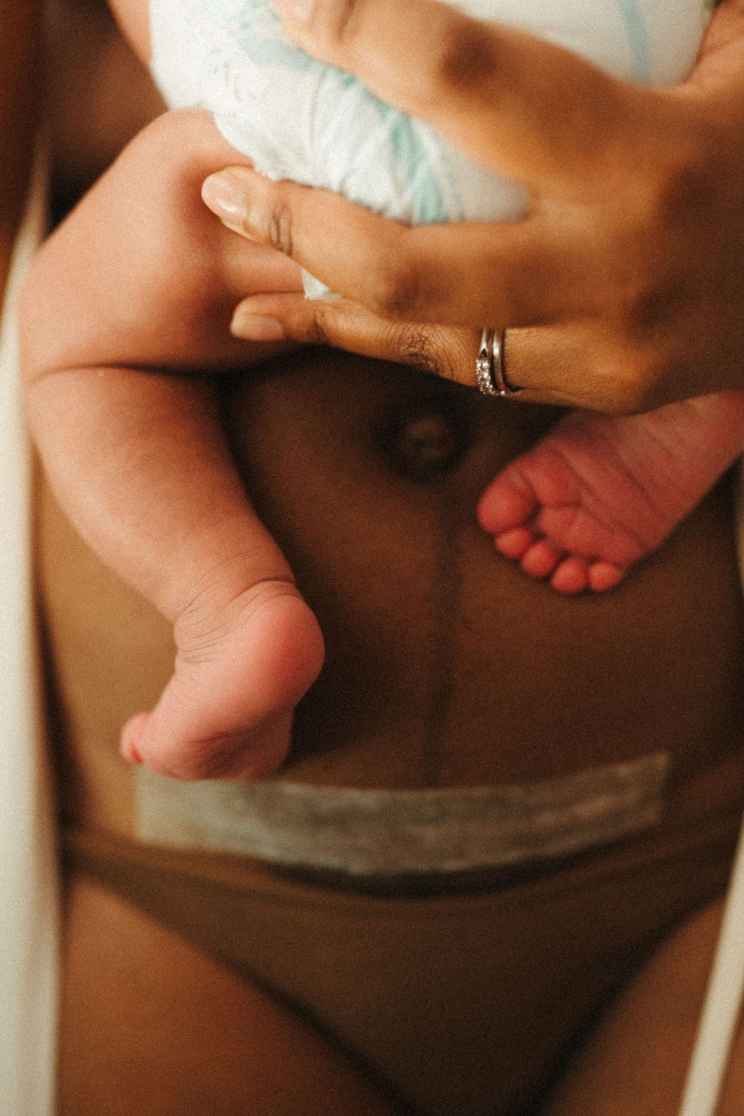 Close-up photography of small baby feet during an intimate nursing session.