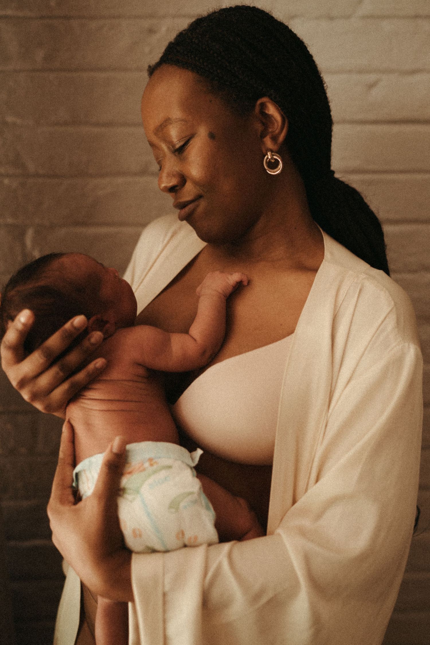 An intimate series of photos showing a mother in white holding and bonding with her infant.