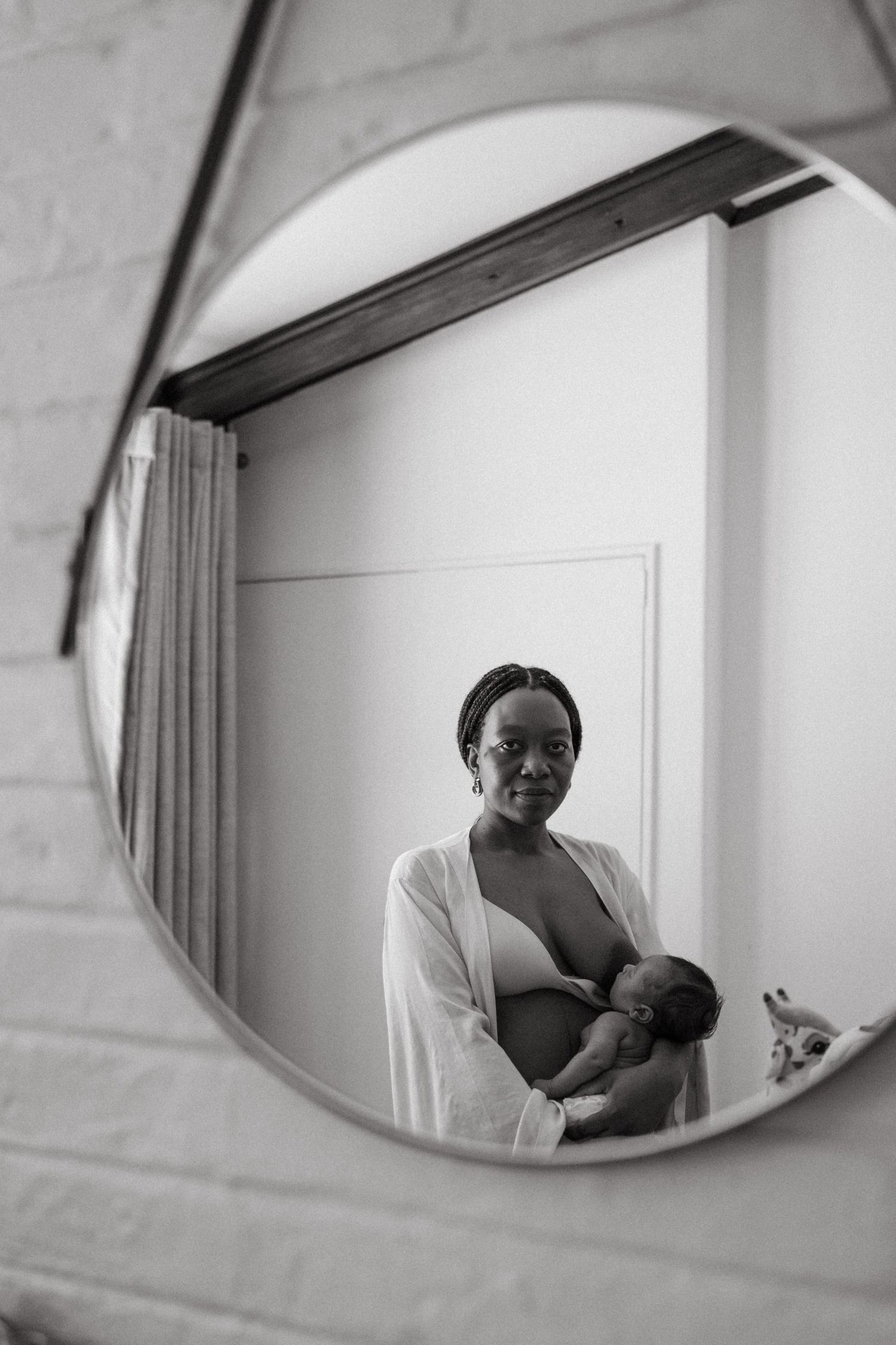 Mirror reflections show quiet moments of parent-child bonding in a bright room.