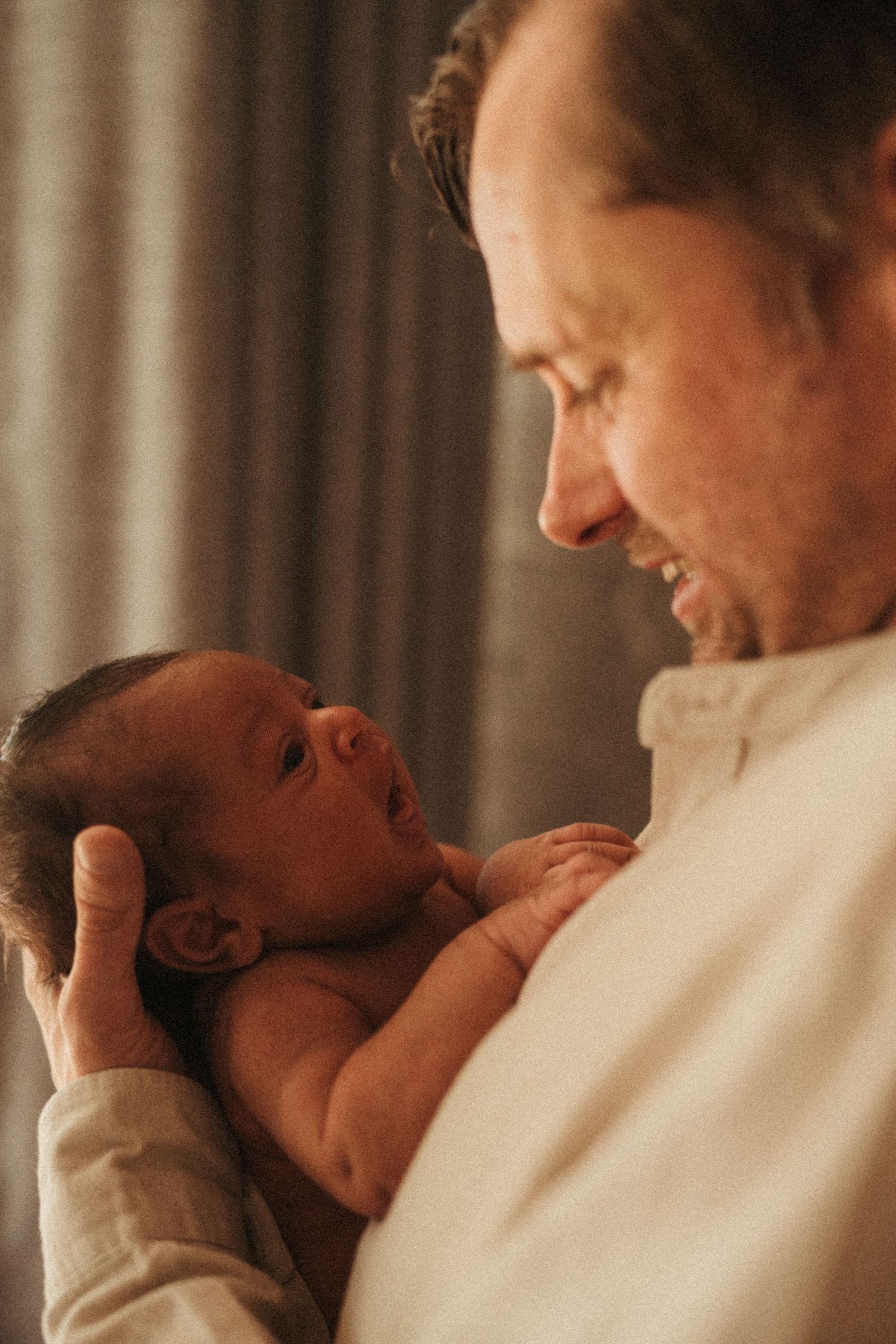 Warm-toned photos capturing intimate bonding moments with a newborn baby.