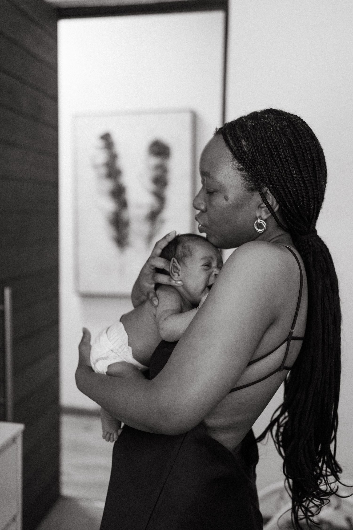 A sequence of black and white photographs showing loving moments between mother and baby.