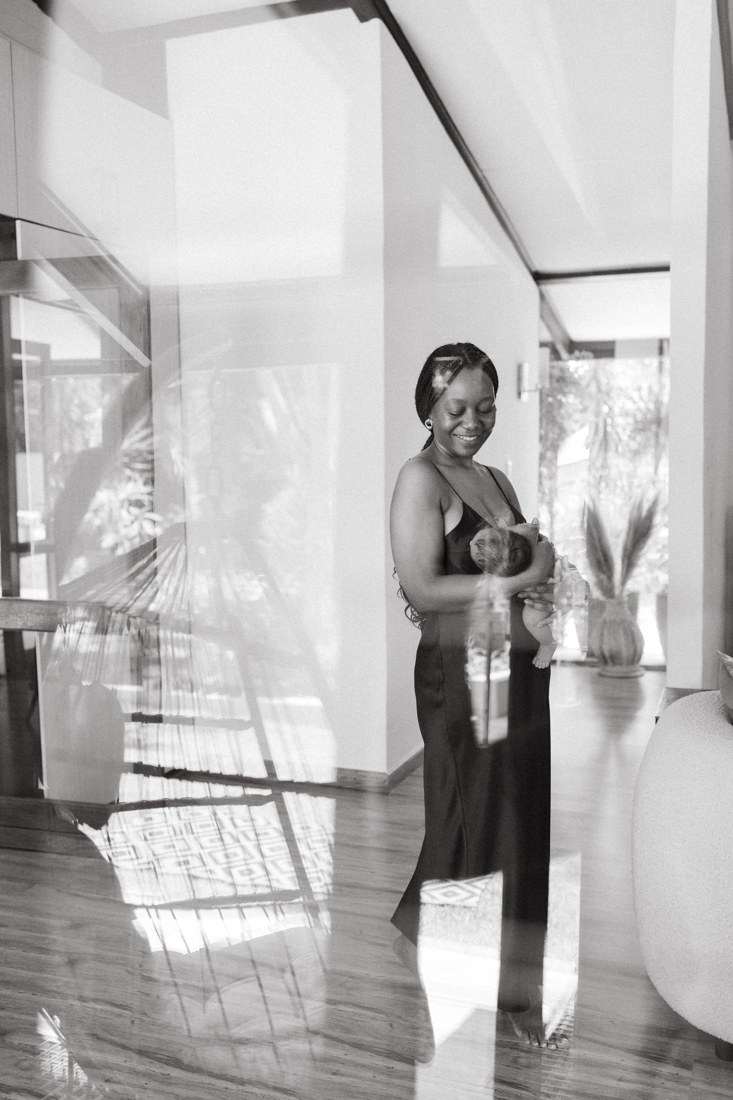 Black and white photos of a woman dancing joyfully in an indoor space with natural lighting.