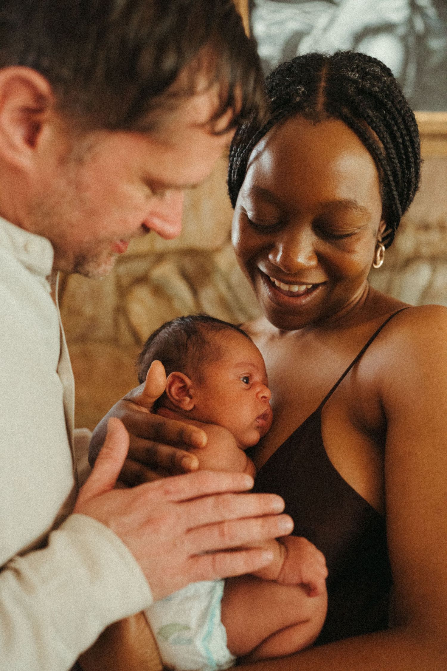 A heartwarming series showing parents bonding with their newborn baby in warm lighting.