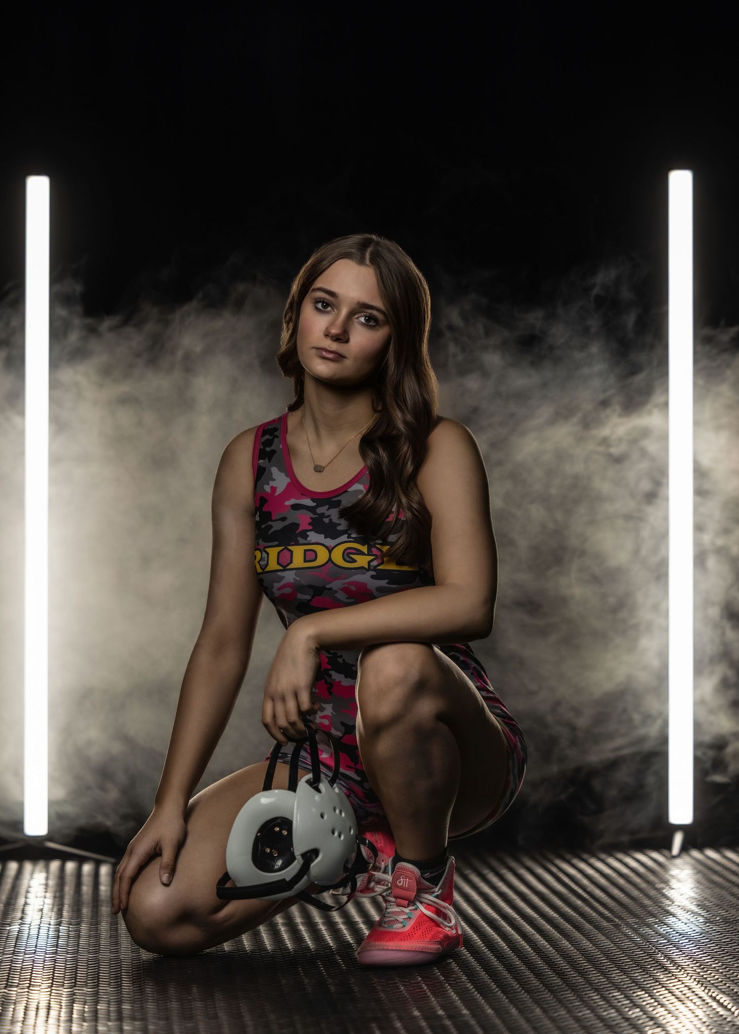 Athletic portrait with dramatic lighting and smoke effects on metal surface.