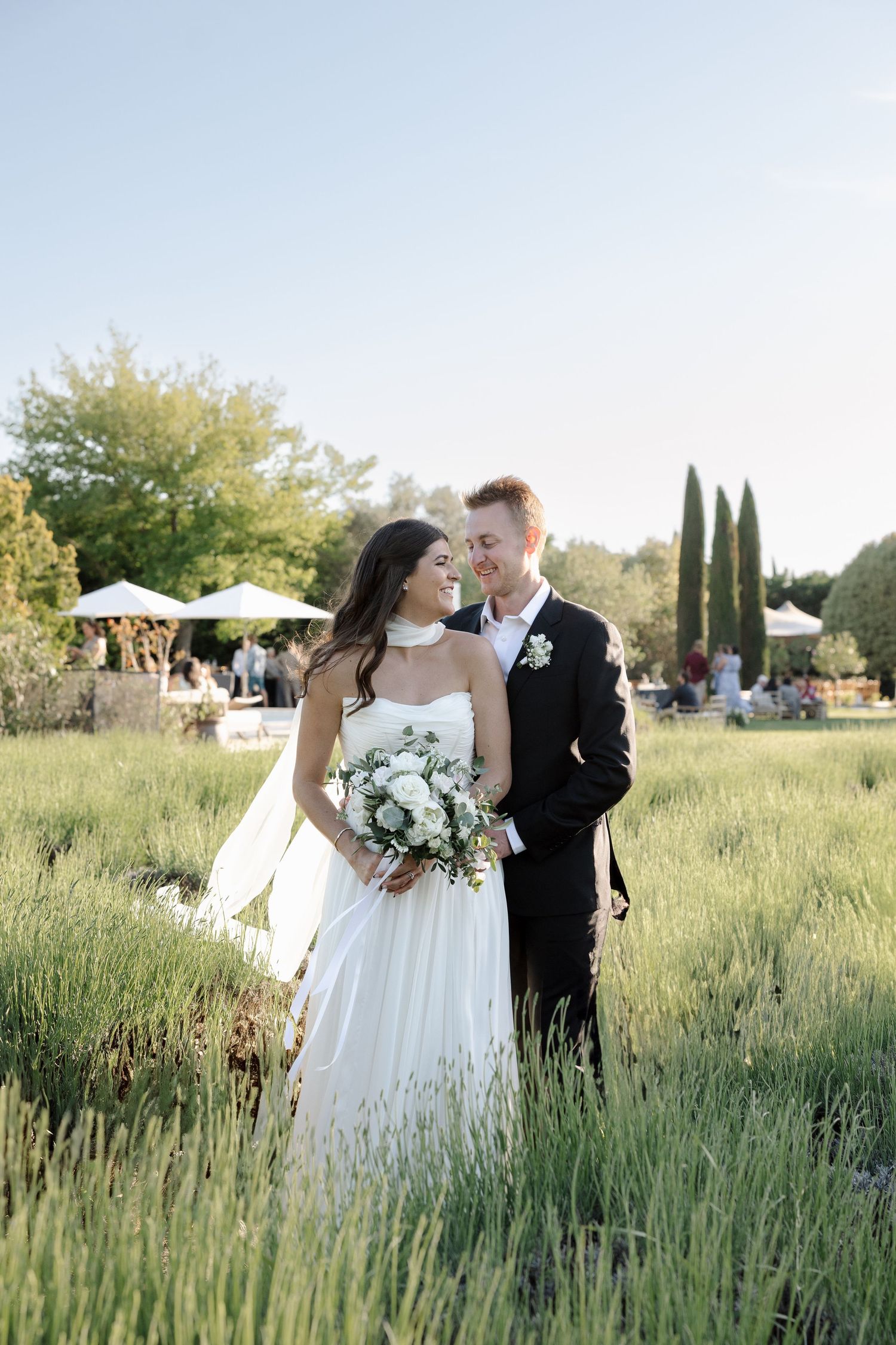 Romantic wedding photos in lavender field with white floral bouquet.