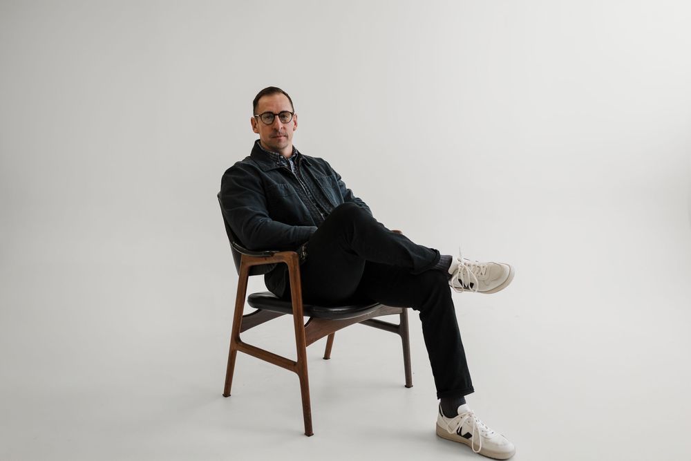 A minimalist studio setup with a wooden chair against a white background in a contemporary style.