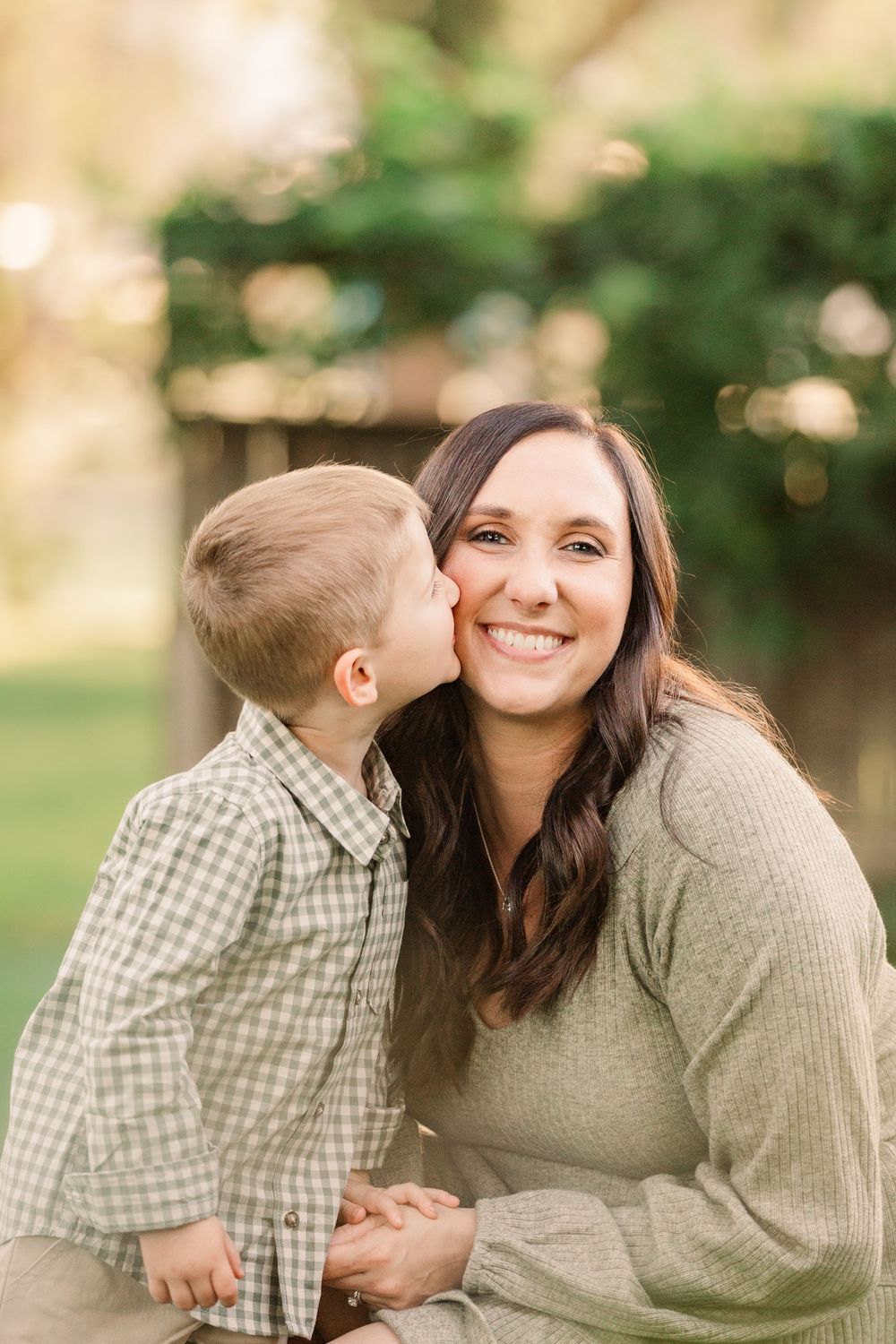 Sweet candid moment between parent and child in green garden setting.