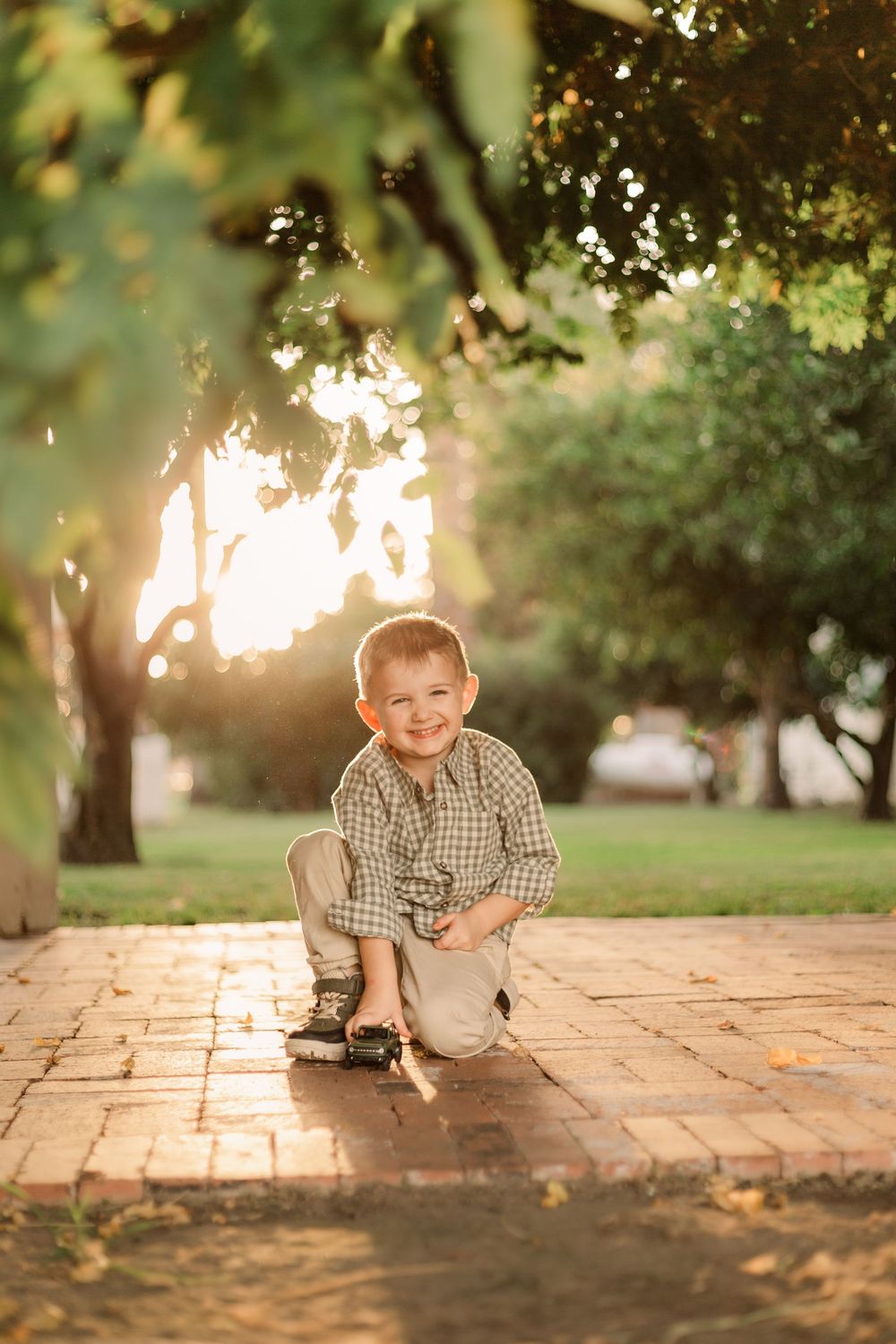 Child plays on brick patio during golden hour.