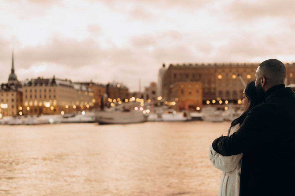 couple looking at the view in central Stockholm during pink sky sunset while being captured by documentary cinematic couple photographer