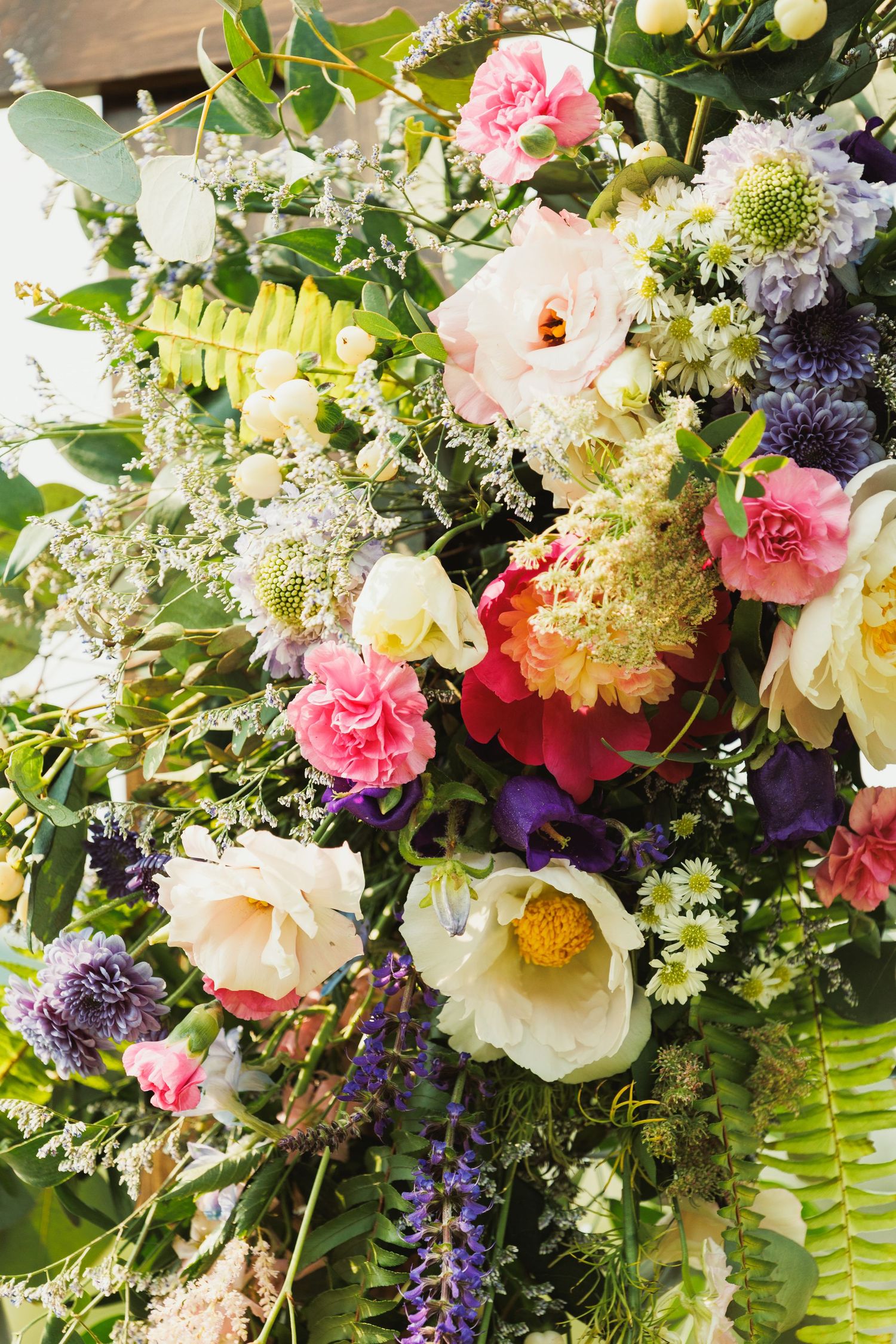 Lush floral arrangement with pink roses, white hydrangeas, and purple blooms creating an elegant garden display.