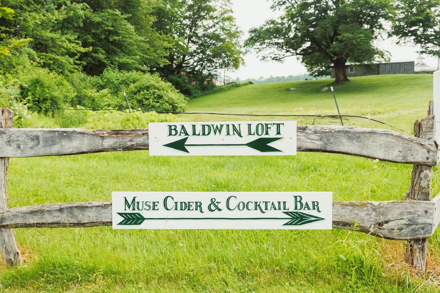 Baldwin Loft venue sign on stone wall with lush green landscape.
