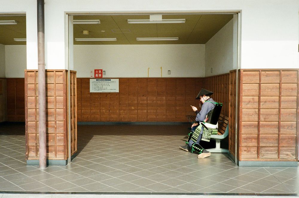 Long empty hallway with brown brick walls and tiled floors showing multiple connected corridor segments.