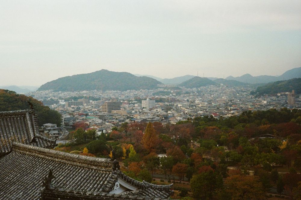 Panoramic cityscape view of mountains and urban development in Asia during autumn season.