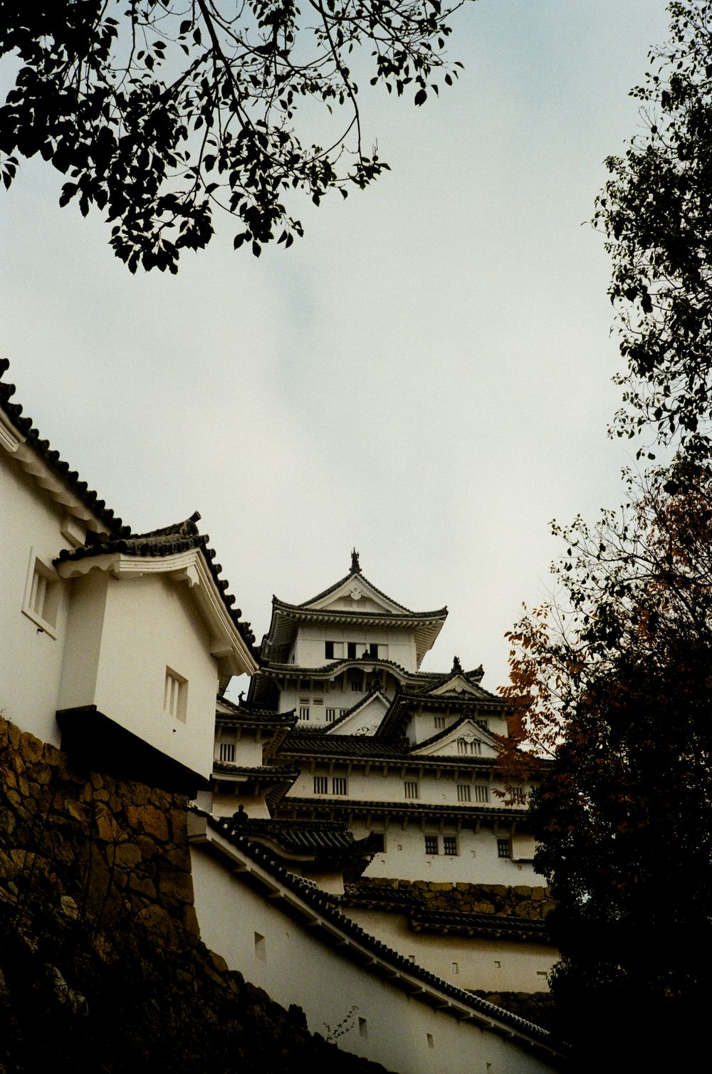 Four sequential photos show different angles of a traditional Japanese castle tower with white walls and dark tiled roofs.