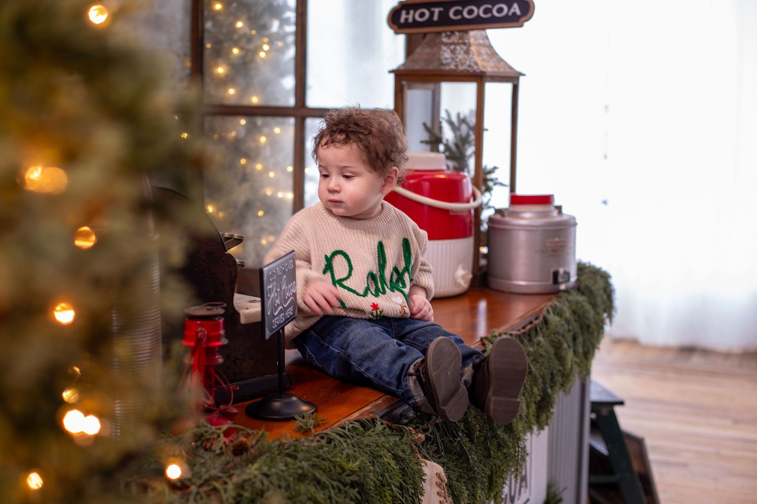 11 month old baby sitting for a Christmas portrait in a Cincinnati studio, soft holiday setup capturing sweet details and milestone moments.