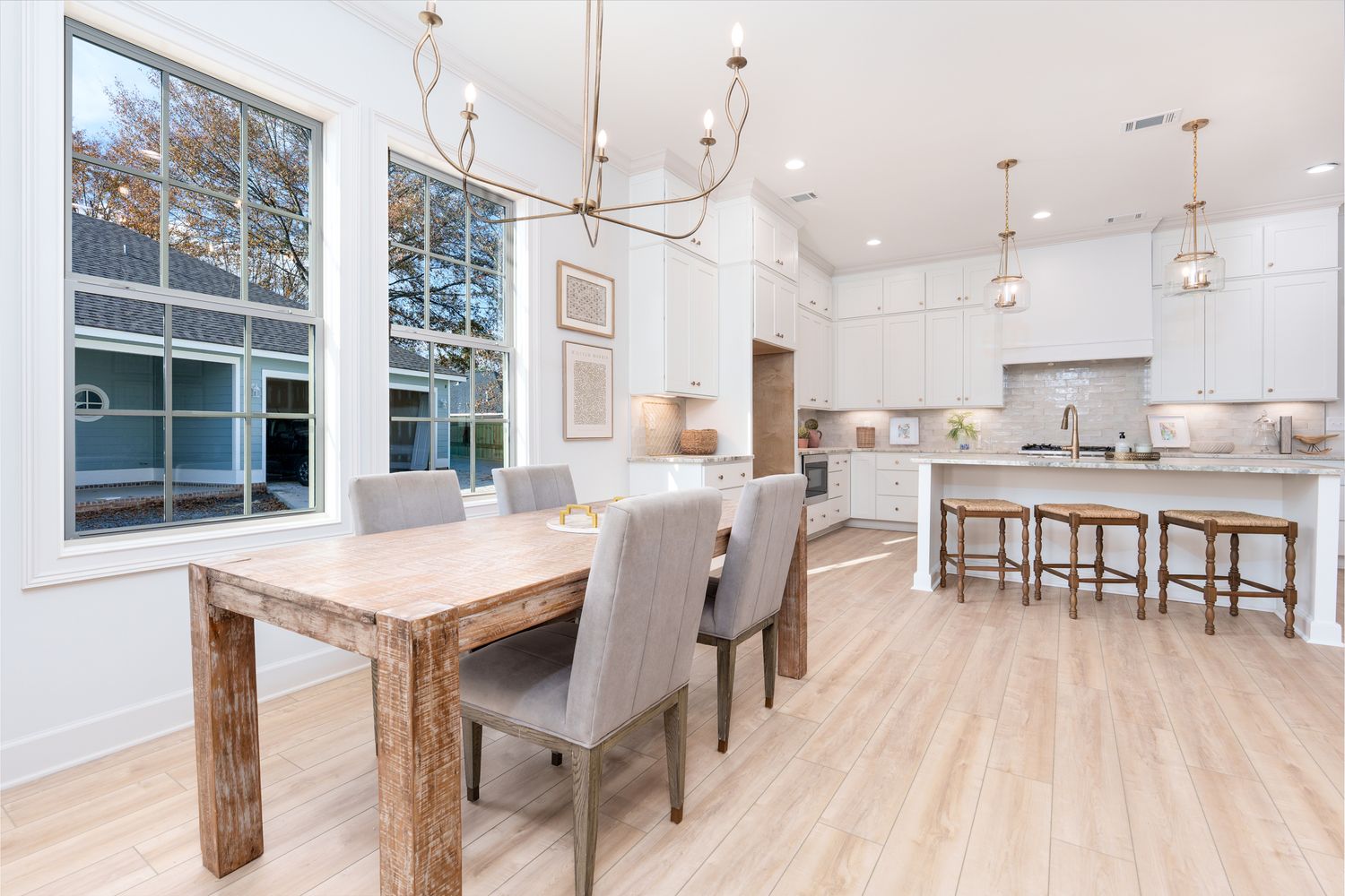 Contemporary white kitchen featuring pendant lights and natural wood accents.