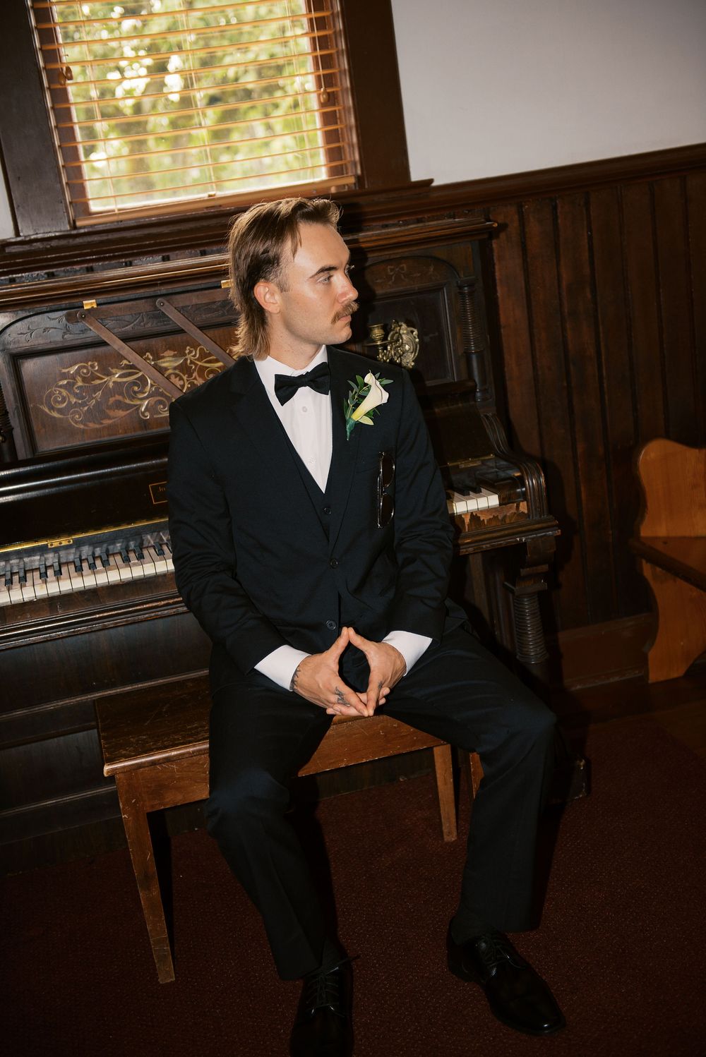 A series of photos showing a groom in a black tuxedo sitting thoughtfully in a church setting.