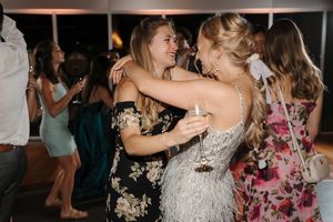 Wedding guests dancing and celebrating on a dance floor during a reception party.
