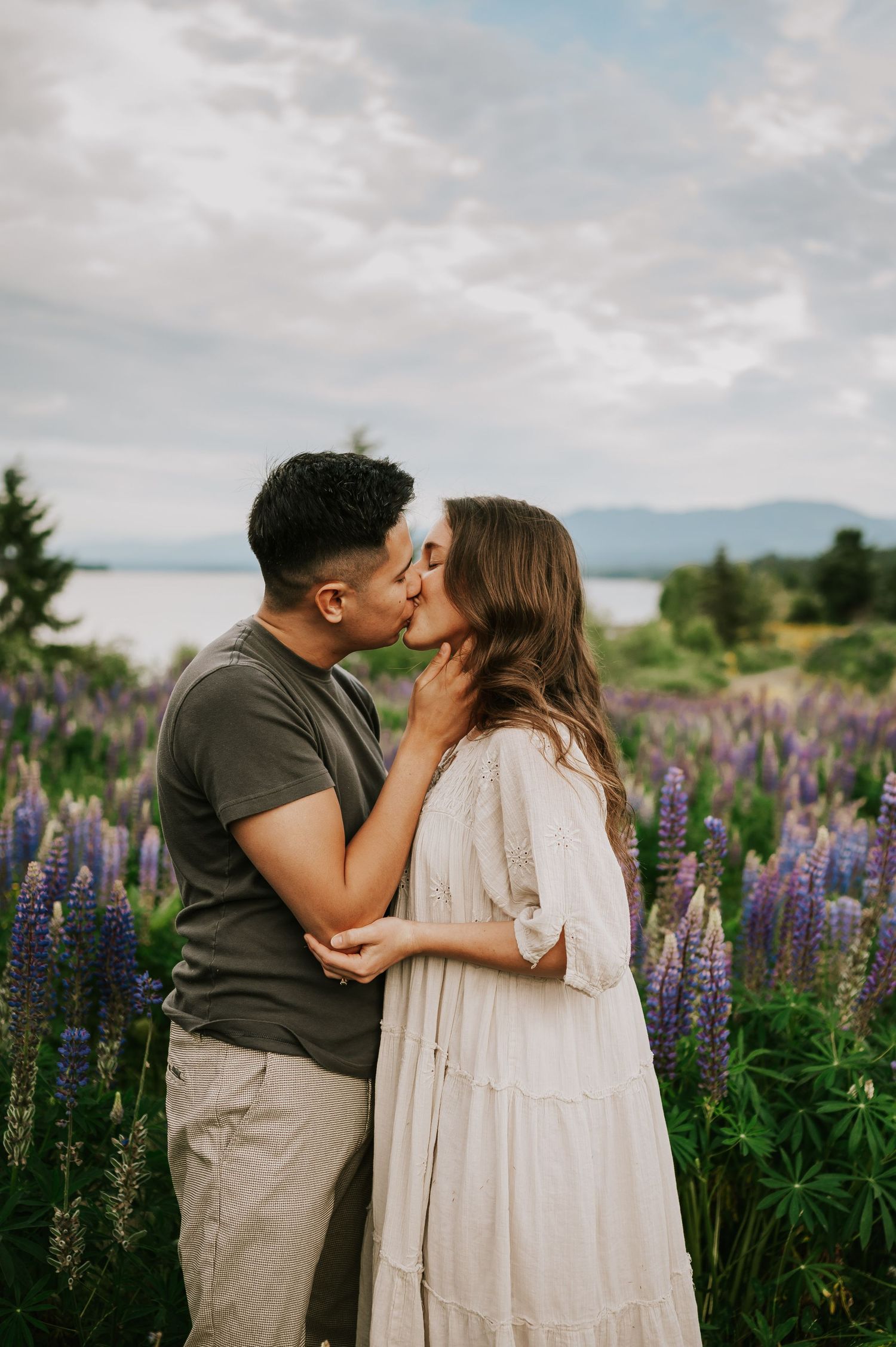 Couple kissing in lupine field by ocean Comox Valley wildflower field locations Photography by Photographer Soulfull Photographs