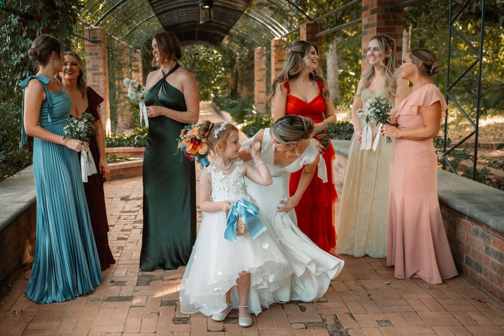 Candid portrait of bride with flower girl and bridesmaids during a Weatherford Texas Wedding